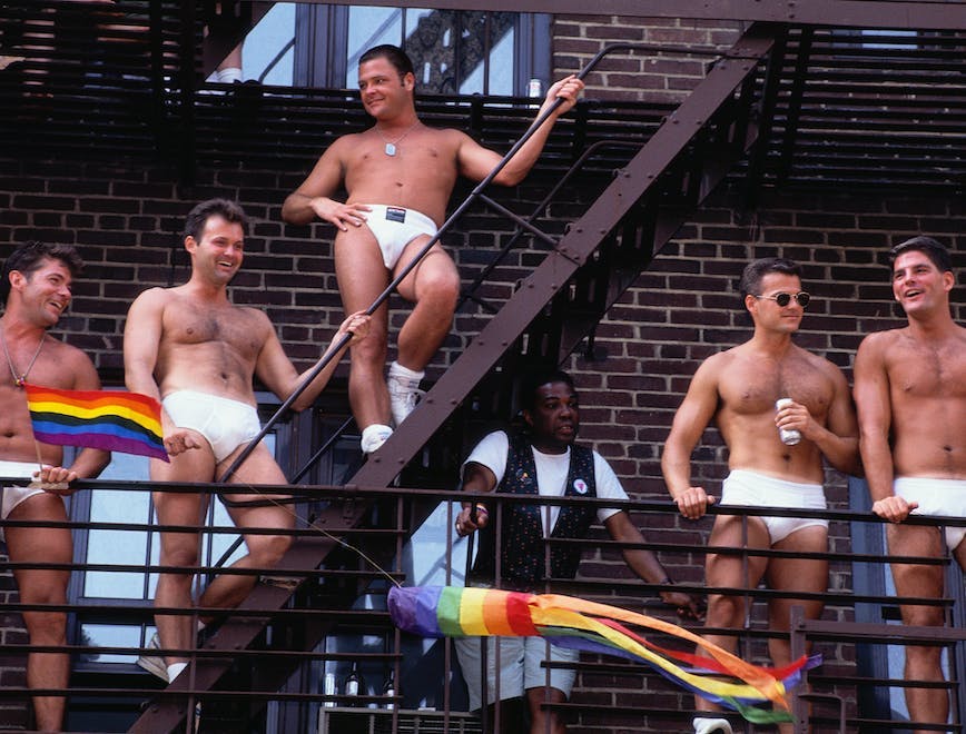 enjoyment:cb2 festivity:cb2 african-american ethnicity:cb3 ethnic diversity:cb2 group of people:cb3 gay male:cb3 caucasian ethnicity:cb3 political and social issues:cb2 urban scene:cb2 partially nude:cb2 gay rights:cb2 outdoors:cb2 celebrating:cb3 latin american and hispanic ethnicity:cb3 american:cb3 fire escape:cb3 city:cb2 pride parade:cb2 manhattan:cb2 person human skin back clothing apparel sport sports