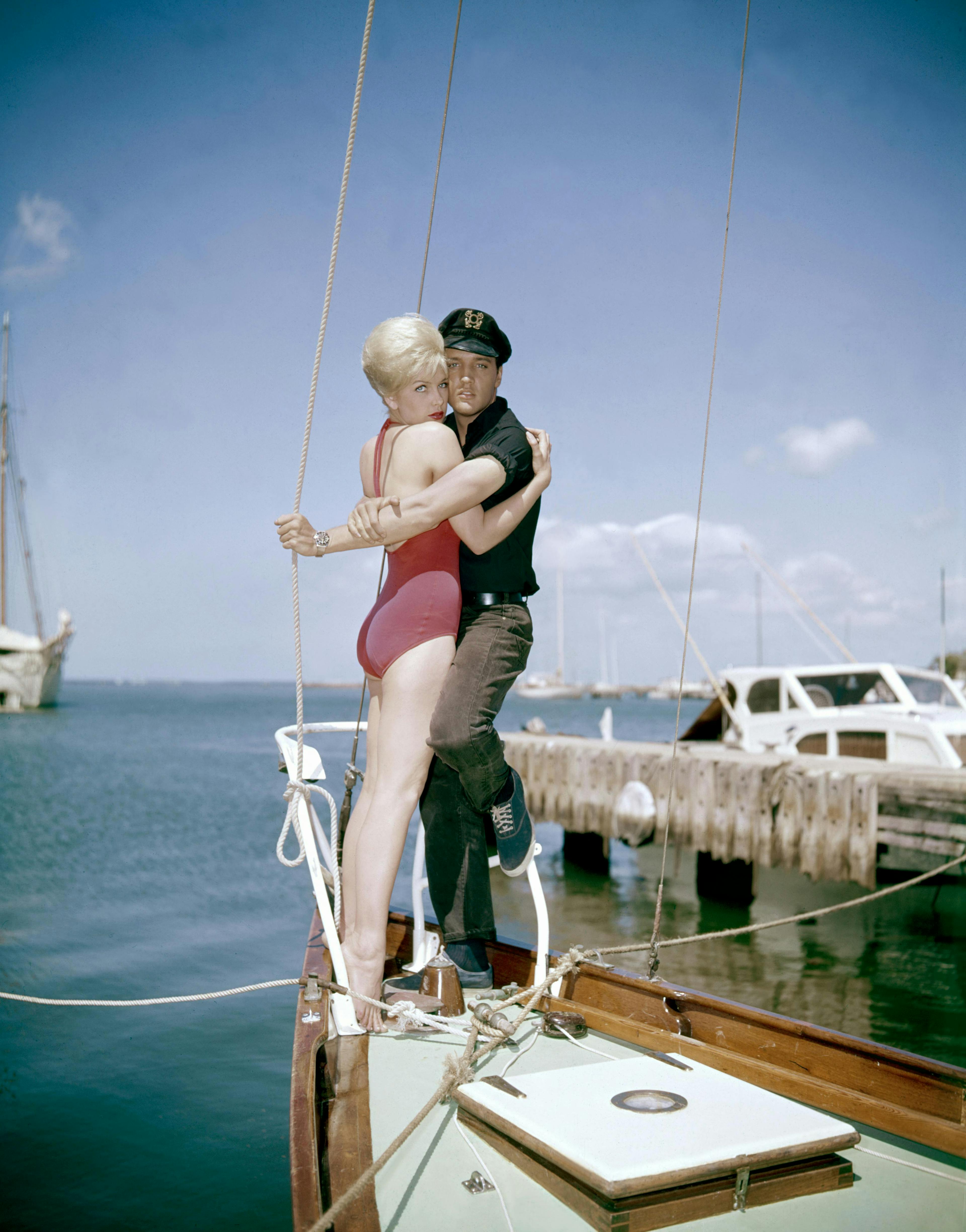 1960s two people young adult man young adult woman caucasian ethnicity movie set sailboat actress actor performing arts singer music celebrities hugging american movie film still hawaii elvis presley stella stevens waterfront boat yacht port watercraft back person shorts pier
