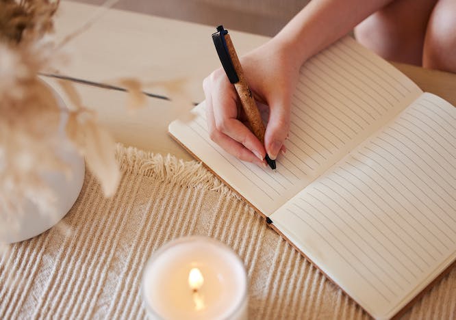 person writing pen candle
