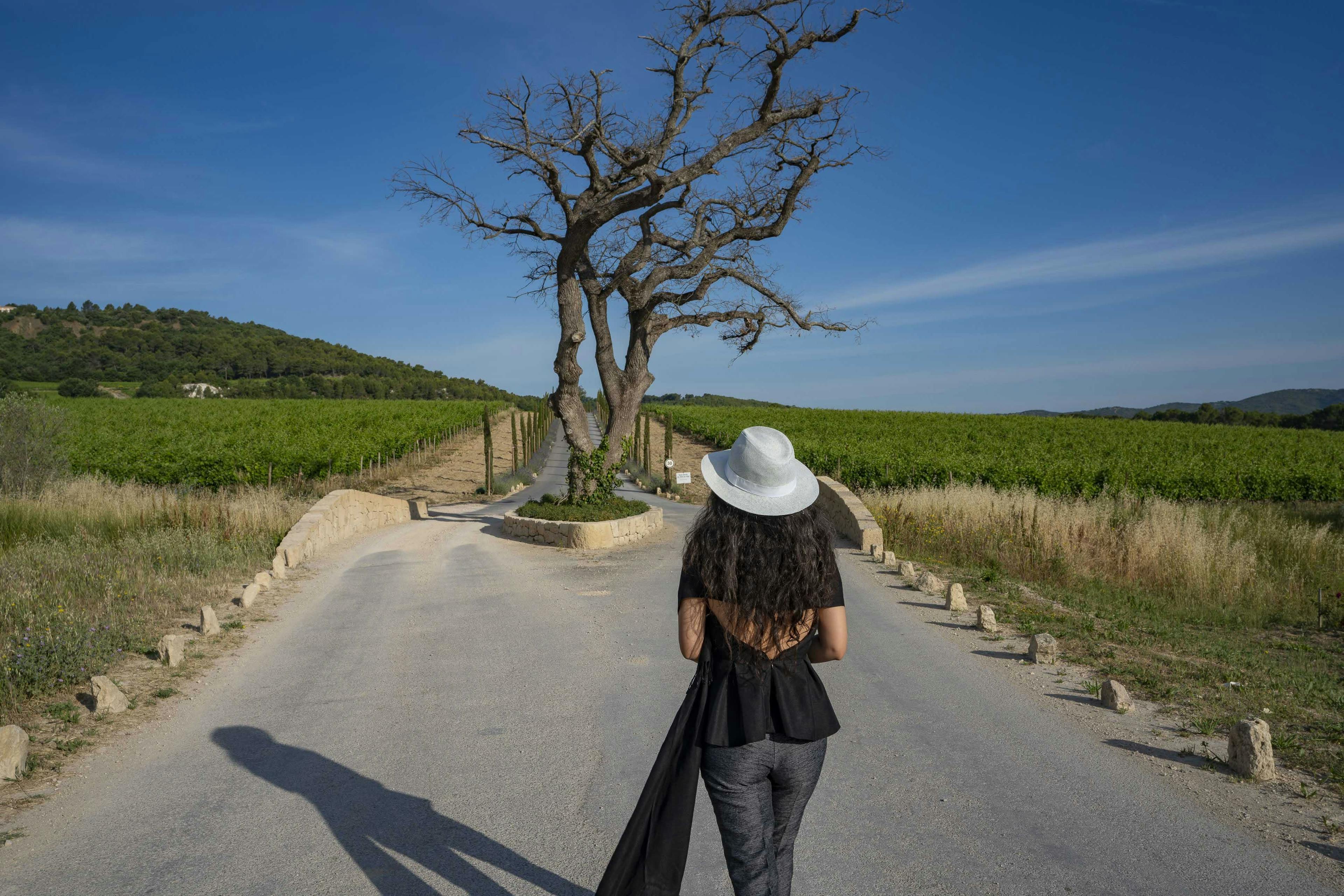 person walking hat sun hat tree pants photography road adult woman